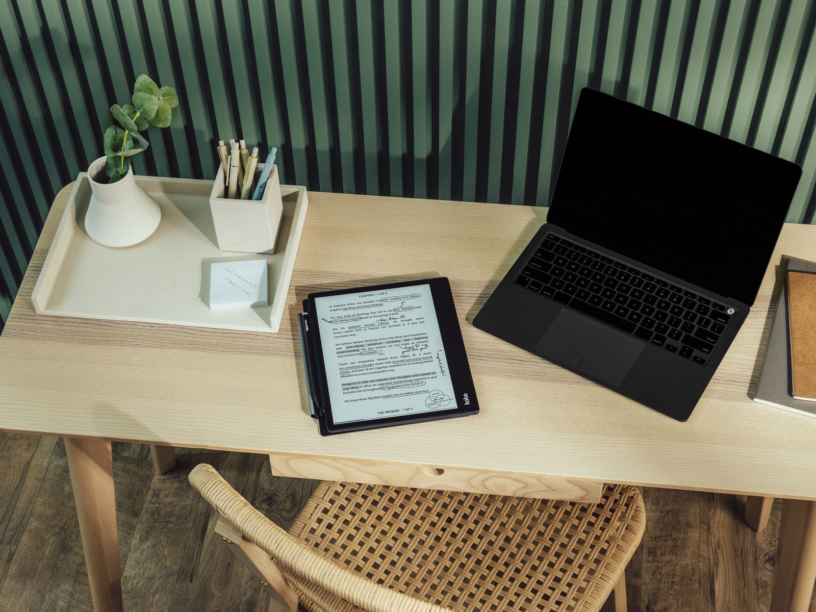 Tablette liseuse Kobo Eclipsa 2E sur un bureau à côté d'un ordinateur portable et de plantes